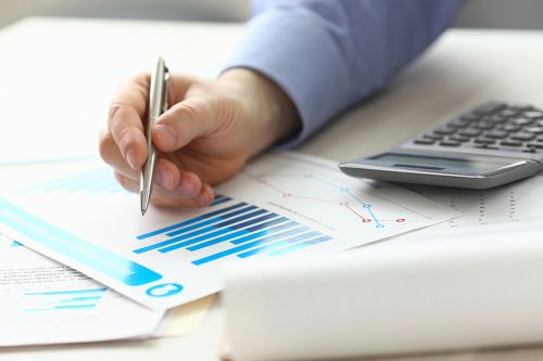 Foto: Person zeigt mit Stift auf Akten